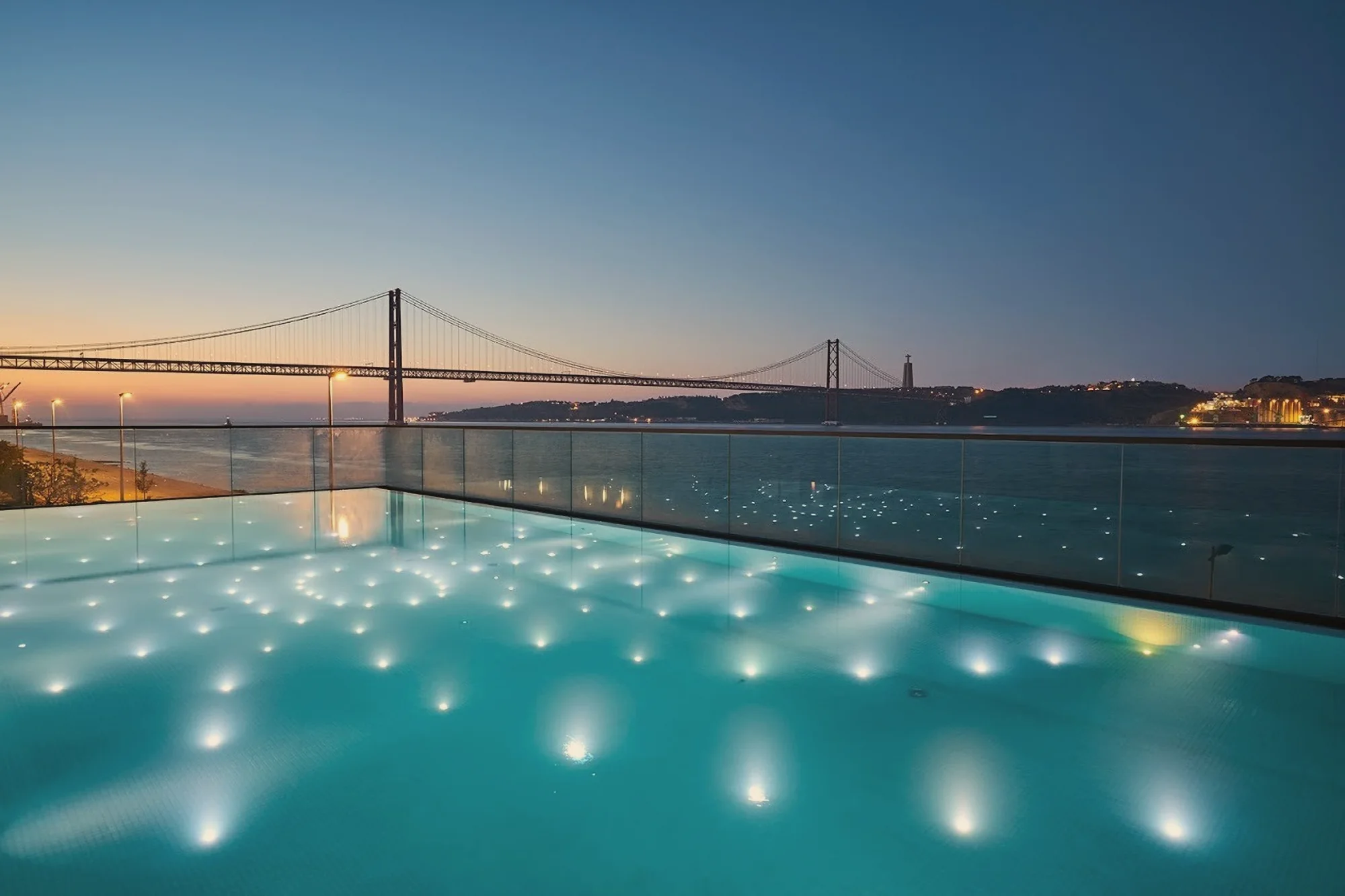 The pool at SUD Lisboa, looking across to the bridge at dusk