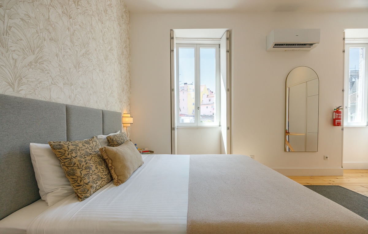 Queen bed by the window with neighbourhood view